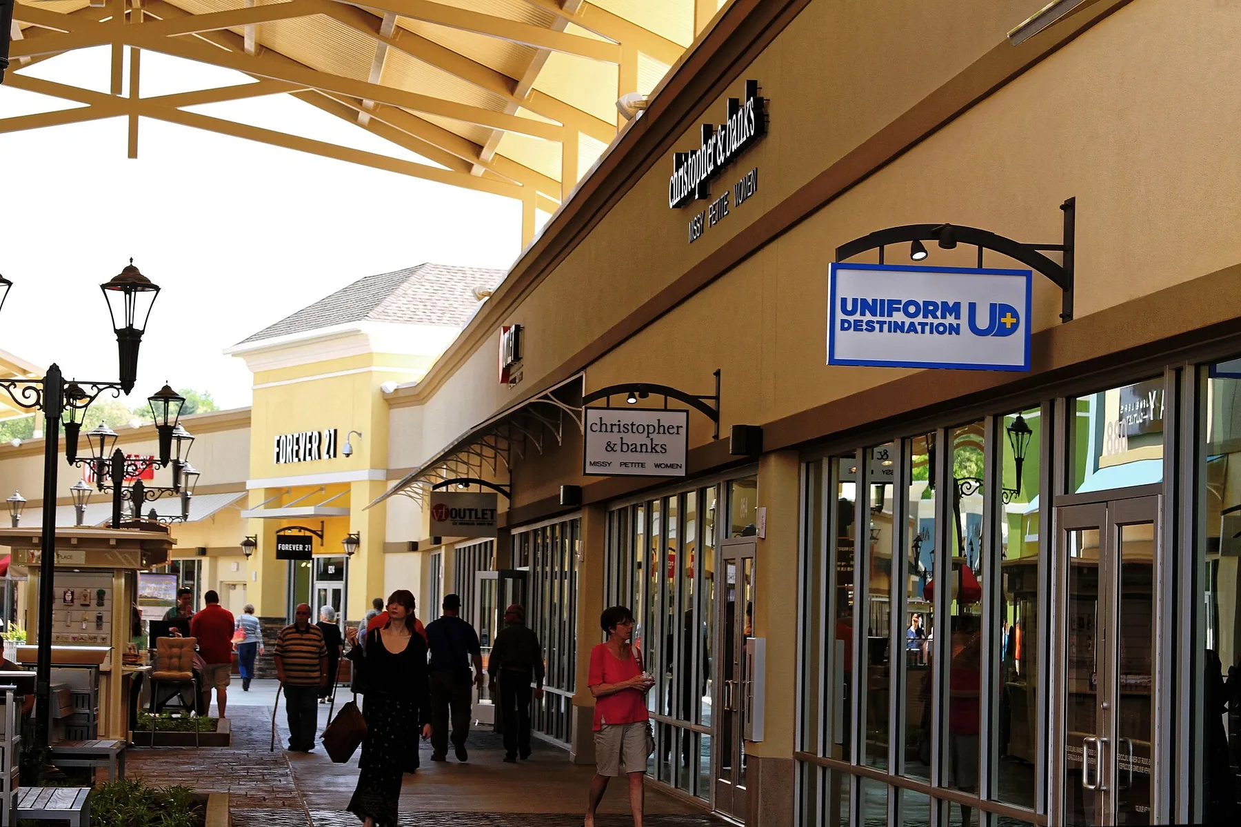 Shoppers walk the covered storefronts at the outlet center on Brevard Road in Asheville.