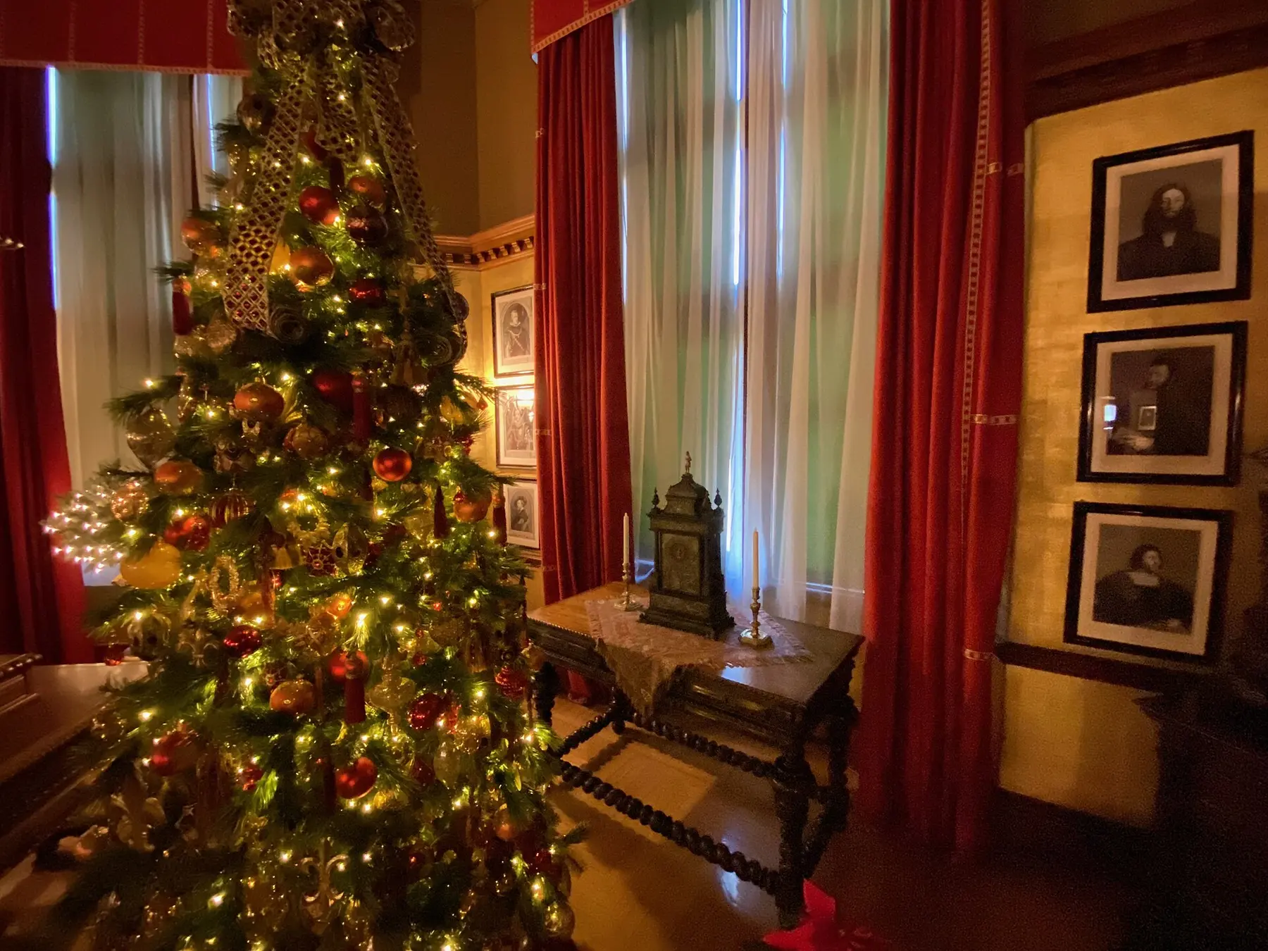 A lit Christmas tree decorated with red and gold ornaments inside Biltmore House on the Biltmore Estate in Asheville.