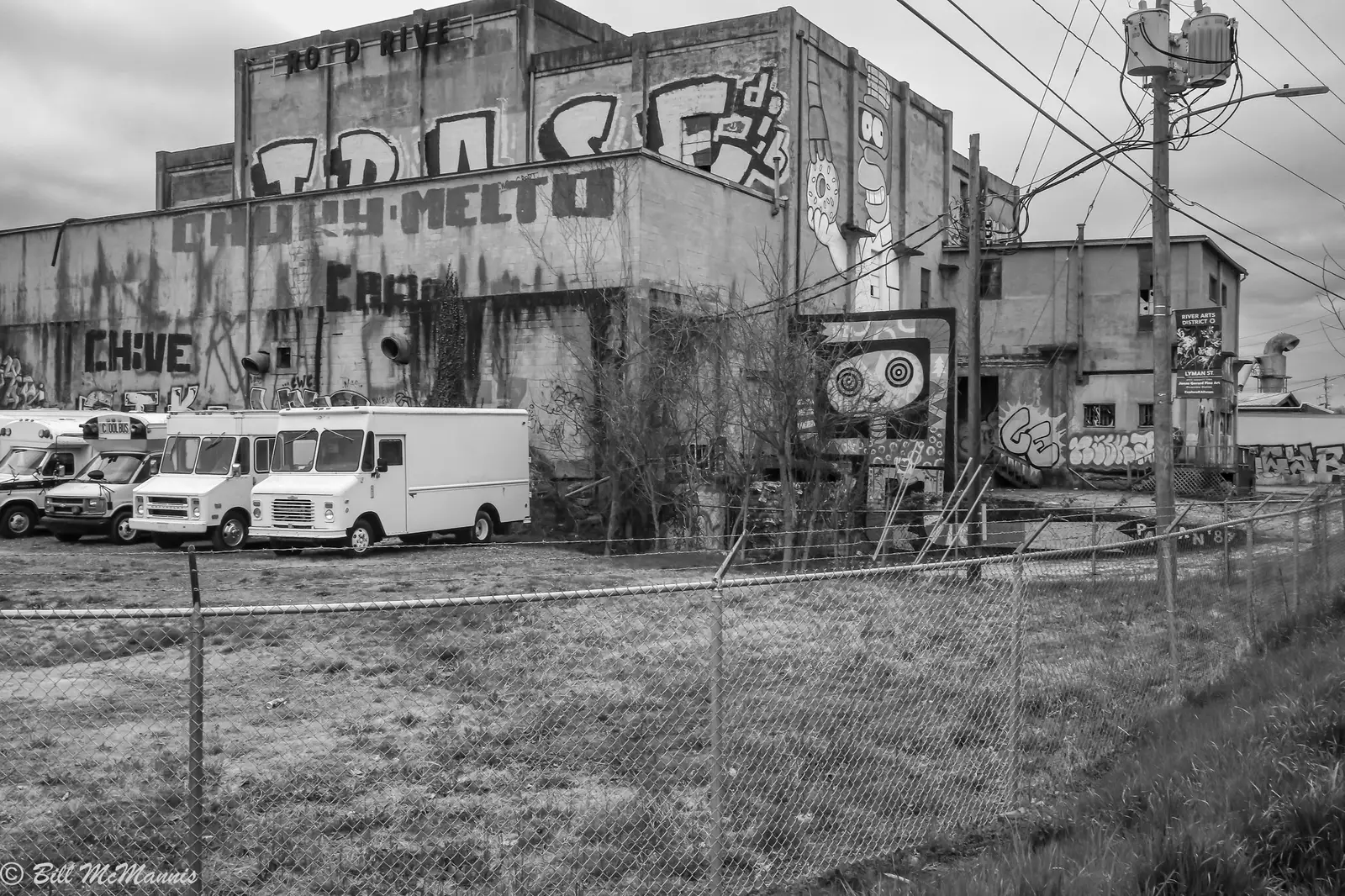 Delivery trucks parked beside graffiti-covered industrial buildings in the River Arts District in Asheville
