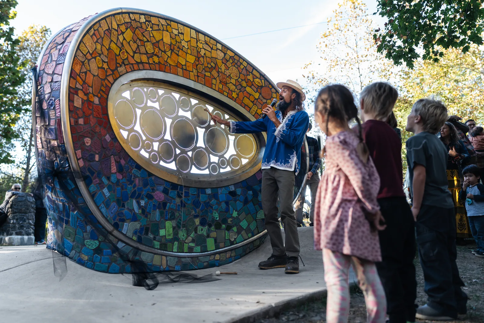 Musician JoEL Karabo Elliot plays the new sound sculpture on the Reed Creek Greenway at its ribbon cutting.