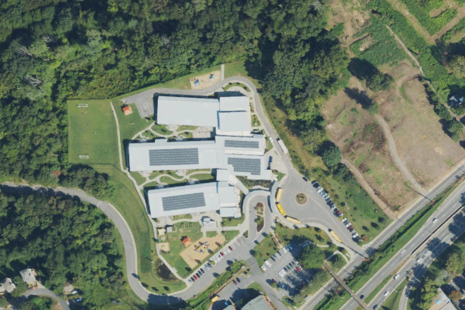 Isaac Dickson Elementary School's building, solar roofs and playground on Hill Street in Asheville, seen from the air