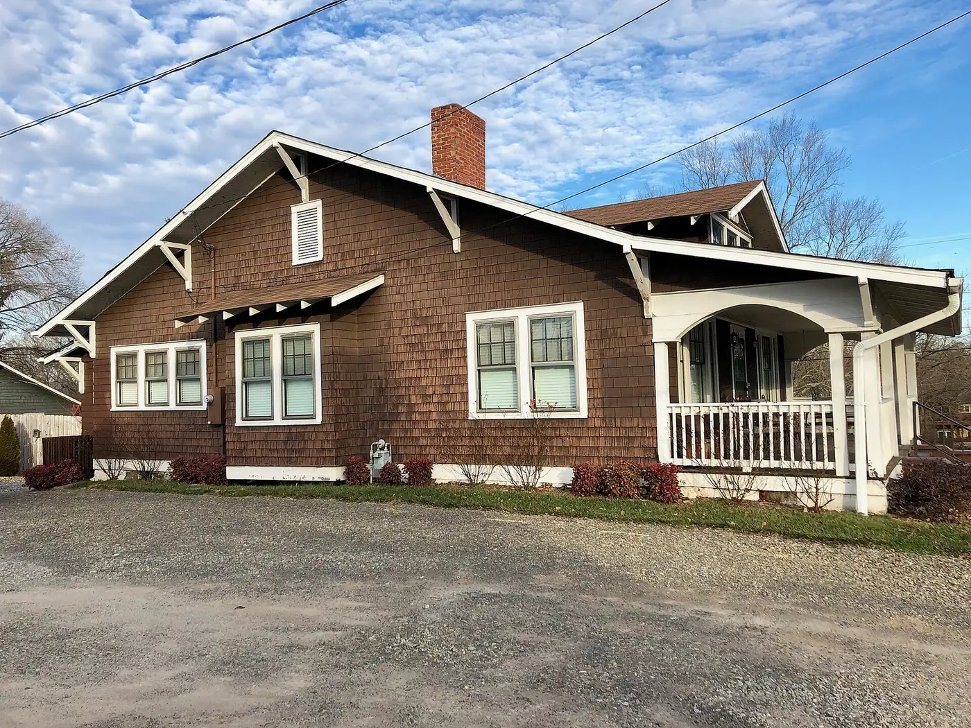 A shingled bungalow with a front porch on Haywood Road in West Asheville.