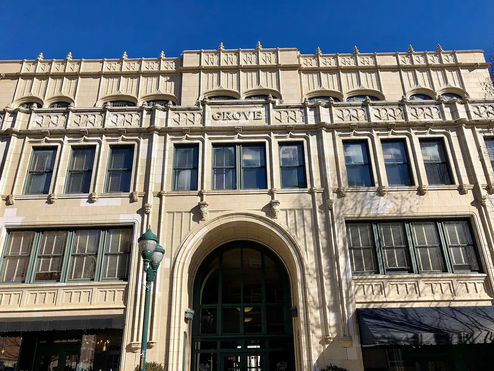 The arched entrance and terra-cotta front of the Grove Arcade in downtown Asheville, home to Huli Sue's BBQ and Grill and other shops.